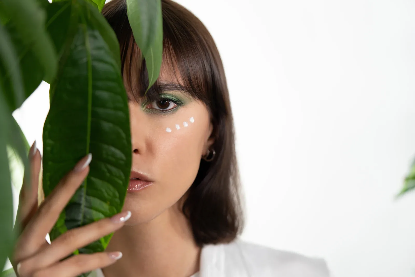 Femme derrière une feuille verte
