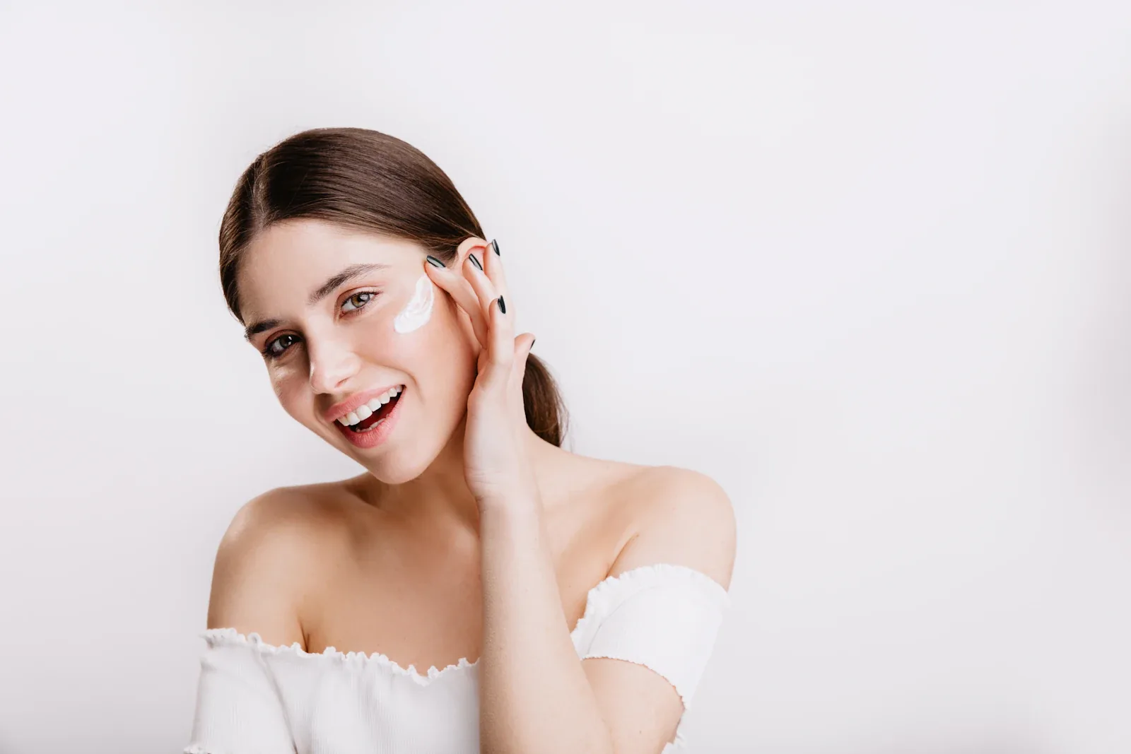 Femme appliquant une crème hydratante sur le visage